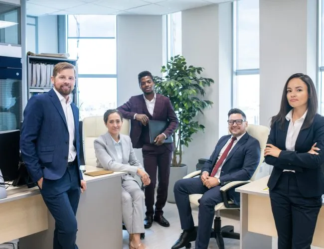 Large group of young successful intercultural white collar workers in open space office